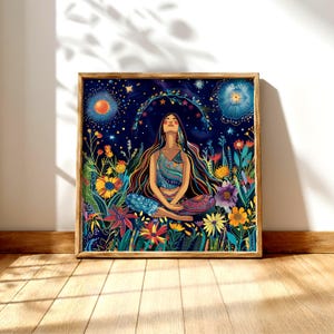 May include: A framed art print depicts a woman meditating in a field of colorful flowers under a starry night sky. The artwork features vibrant blues, greens, yellows, and purples, with a wooden frame.