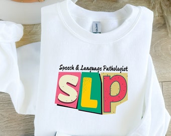 May include: White sweatshirt with the text "Speech & Language Pathologist" and the letters "SLP" in colorful blocks.