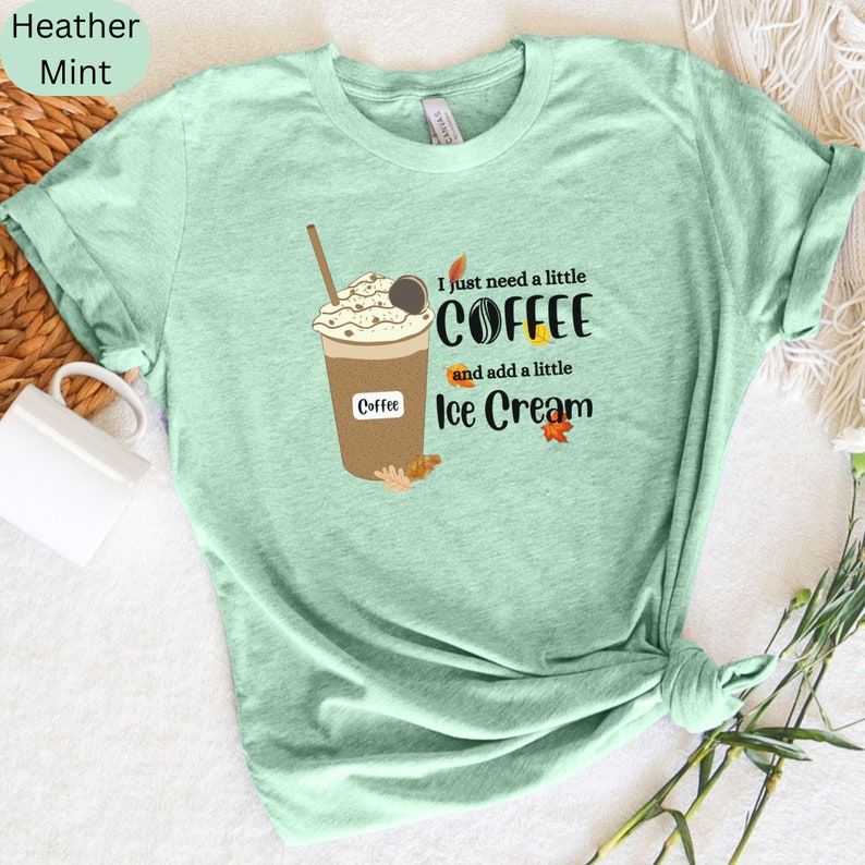 May include: A mint green t-shirt featuring a graphic of a coffee drink with whipped cream and the text "I just need a little coffee and add a little ice cream." The shirt also has the words "Heather Mint" printed on it.