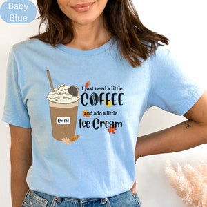 May include: Baby blue t-shirt with a graphic of a coffee drink with whipped cream, a cookie, and the text "I just need a little COFFEE and add a little Ice Cream".