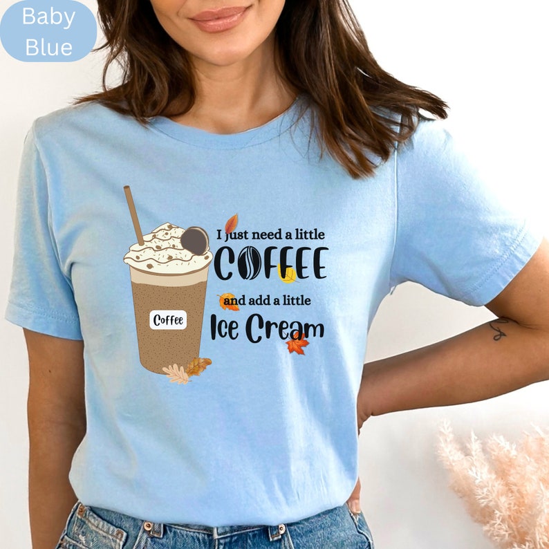 May include: Baby blue t-shirt with a graphic of a coffee drink with whipped cream, a cookie, and the text "I just need a little COFFEE and add a little Ice Cream".