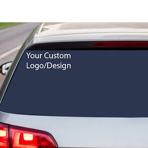 May include: A silver car with a dark blue rear window. The window has a white decal that says "Your Custom Logo/Design".