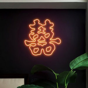 May include: A neon sign featuring the Chinese character for "double happiness" in orange, lit against a dark backdrop.
