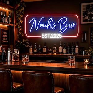 Könnte beinhalten: Ein rechteckiges Neonschild mit rotem Rand, das den blauen Schriftzug Noah's Bar und den weißen Text EST. 2025 zeigt. Das Schild ist an einer dunklen Wand über einer hölzernen Bartheke mit verschiedenen Glasflaschen, Kristallgläsern und Lederhockern montiert.