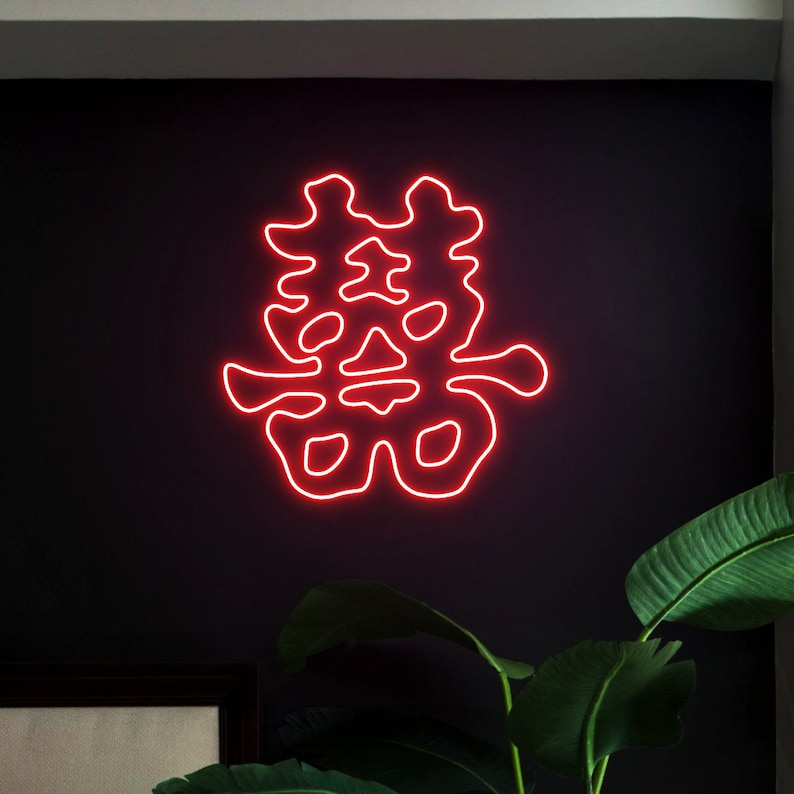 May include: Red neon sign with the Chinese characters for "double happiness" on a black wall.