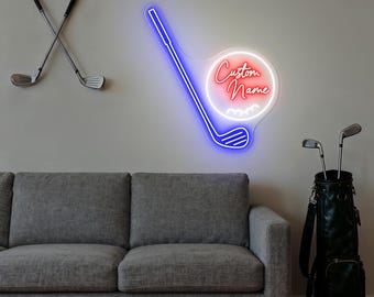 Puede incluir: Un letrero de neón con forma de palo de golf con las palabras "Custom Name" en escritura roja. El letrero está delineado en azul y blanco. Dos palos de golf están cruzados en la pared y una bolsa de golf con palos está en el suelo.