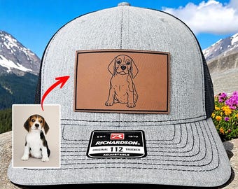 May include: Gray trucker hat with a black mesh back and a brown leather patch featuring a beagle illustration. The hat has the text "RICHARDSON" and "ORIGINAL 112 TRUCKER ADJUSTABLE". A small photo of a beagle is in the corner.