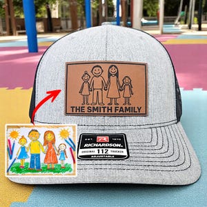 May include: A gray trucker hat with a black mesh back and a brown leather patch. The patch features a family illustration and the text "THE SMITH FAMILY." The hat also has a Richardson patch.