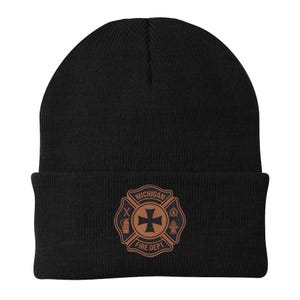 May include: Black beanie featuring a brown emblem with the text "MICHIGAN FIRE DEPT." The emblem includes a Maltese cross, an axe, and a fire hydrant. The beanie is made of a soft, knitted material.