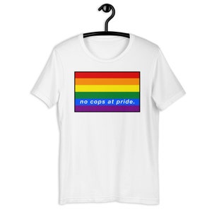 May include: White t-shirt with a rainbow pride flag and the text "no cops at pride."