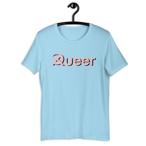 May include: A light blue t-shirt with a pink graphic that says "Queer" with a stylized letter Q.