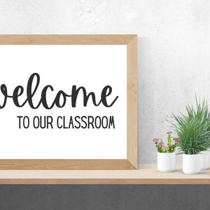 Może przedstawiać: Ramka z napisem "welcome to our classroom" w czarnym, ozdobnym piśmie na białym tle.