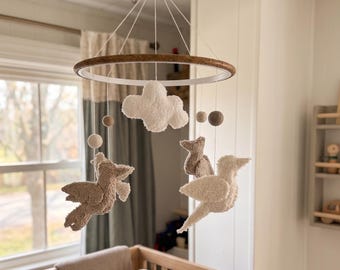 Móvil para bebé con textura de pájaros para una acogedora habitación infantil.