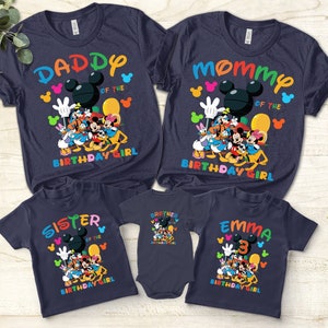 Puede incluir: Camisetas familiares de color azul marino con texto colorido y personajes de dibujos animados. Las camisetas dicen "Daddy", "Mommy", "Sister", "Brother" y "Emma 3" con "of the Birthday Girl" debajo. Mickey Mouse y sus amigos están presentes.