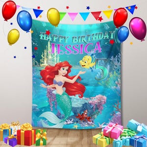 Puede incluir: Una pancarta de cumplea&ntilde;os con Ariel de La Sirenita, con el texto "Happy Birthday Jessica 5". La pancarta est&aacute; decorada con globos y una colorida escena submarina. Hay cajas de regalo en la parte inferior.