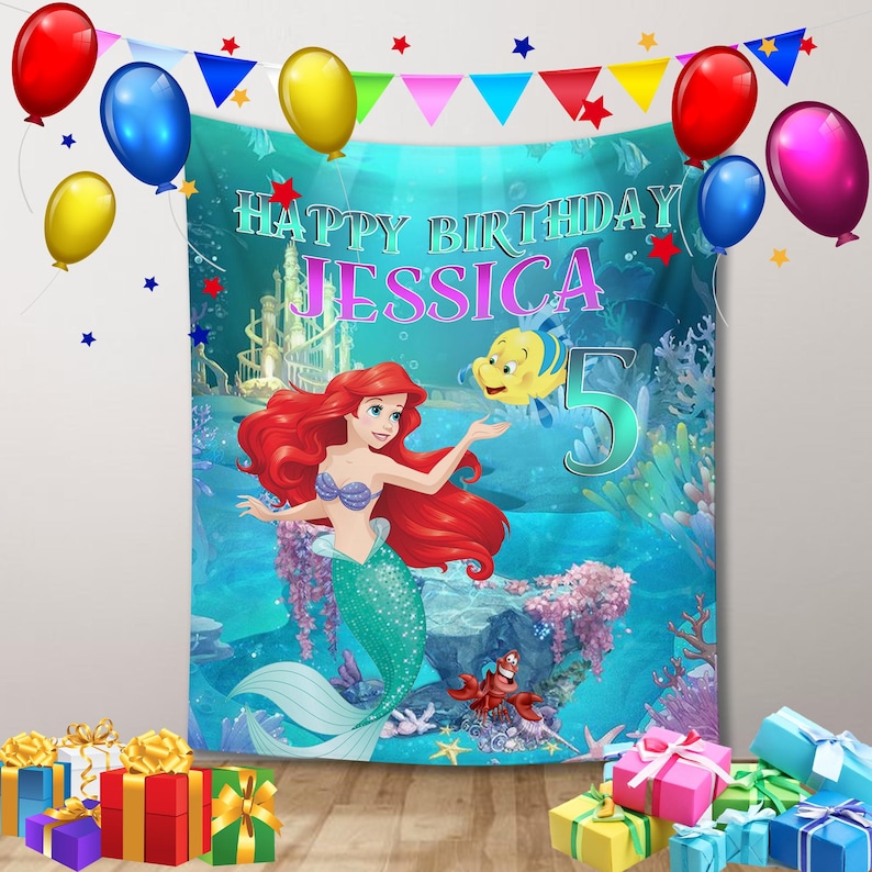 Puede incluir: Una pancarta de cumplea&ntilde;os con Ariel de La Sirenita, con el texto "Happy Birthday Jessica 5". La pancarta est&aacute; decorada con globos y una colorida escena submarina. Hay cajas de regalo en la parte inferior.
