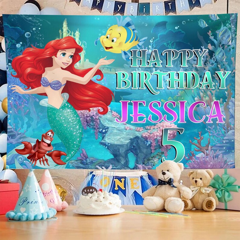 Puede incluir: Escena de cumplea&ntilde;os con un tel&oacute;n de fondo con Ariel de La Sirenita, con el texto "Happy Birthday Jessica 5". La escena incluye una tarta, gorros de fiesta, osos de peluche y regalos, creando un ambiente festivo.