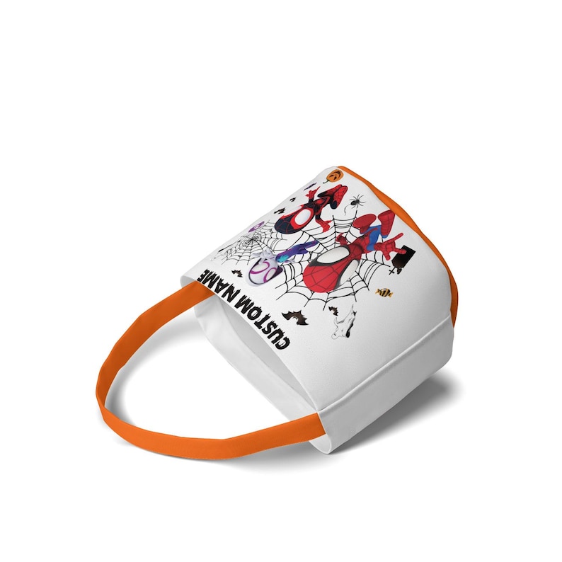 May include: A white fabric bucket with an orange handle and trim, featuring a graphic print of red and blue superhero characters in spider webs, bats, and pumpkins. The text CUSTOM NAME is printed in black on the side of the bucket.