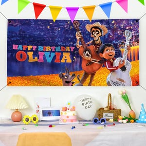 May include: A colorful banner with a scene from the movie Coco. The banner features the characters Miguel and Hector playing guitars. The banner says "Happy Birthday Olivia" in colorful letters.
