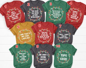 May include: A collection of ten short-sleeved t-shirts in various colors, each featuring a unique humorous phrase within a circle of Christmas lights. The shirts are red, gray, green, and yellow, with phrases like "Well, what's your diel like? Milk and cookies?"