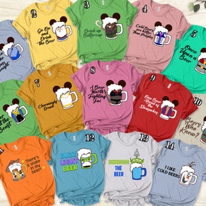 Op de afbeelding: Een set van 14 T-shirts met Disney-figuren met bierbekers. Elk shirt heeft een ander personage en een ander gezegde over bier. De shirts zijn allemaal in verschillende kleuren en hebben verschillende ontwerpen.