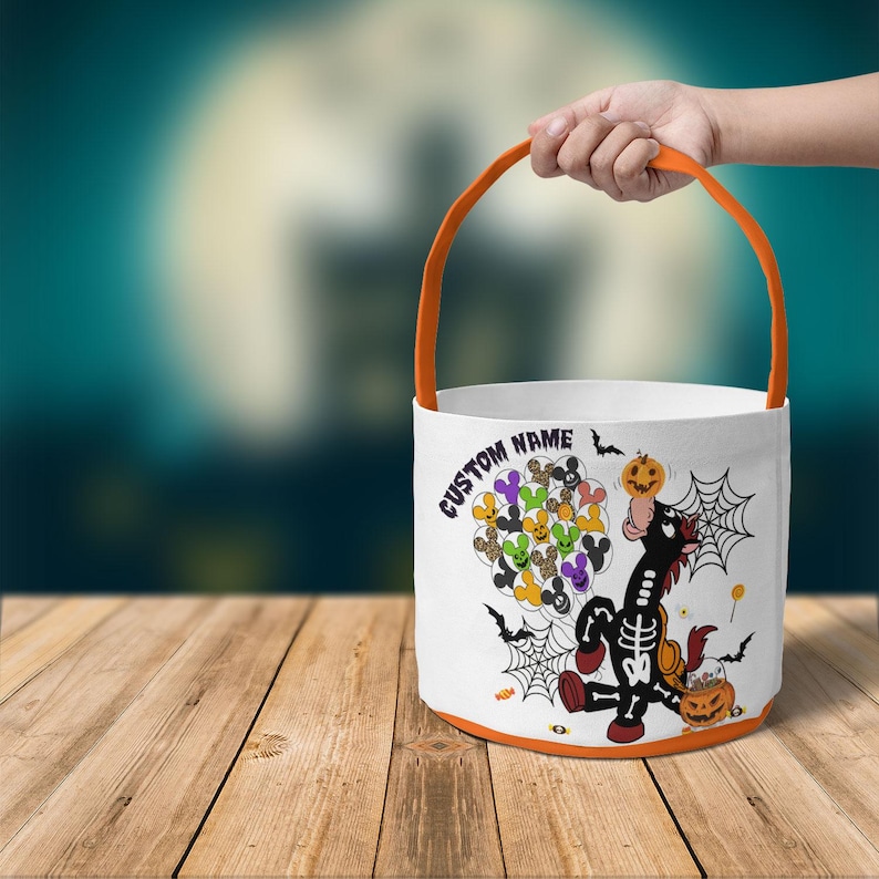 Op de afbeelding: Witte Halloween-emmer met een oranje handvat en rand. De emmer heeft een cartoon skeletpaard met een pompoen, vleermuizen en spinnenwebben. Tekst op de emmer luidt "CUSTOM NAME".