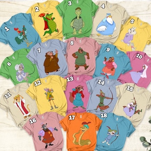 Pode incluir: Dezoito camisetas diferentes com personagens do filme de animação Robin Hood. Cada camiseta é de uma cor diferente e apresenta um personagem diferente do filme. As camisetas são numeradas de 1 a 18.