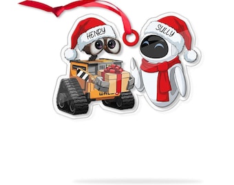 May include: A Christmas ornament featuring two cartoon robots, one named Henry and the other Sully, both wearing Santa hats and red scarves. Henry is holding a wrapped gift. The ornament has a red ribbon for hanging.