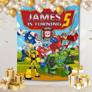 Peut inclure: Une bannière de fête Transformers bleue et rouge avec le texte "JAMES IS TURNING 5" et des images des personnages Transformers.