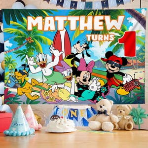 May include: A vibrant birthday banner with Disney characters on a beach background. The banner displays "MATTHEW TURNS 1" in orange lettering. Mickey Mouse, Donald Duck, Goofy, Pluto, and Minnie Mouse are illustrated. A red and white surfboard is also present.