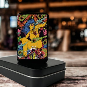 May include: A black lighter with a colorful graphic of a woman riding a skateboard with a comet tail. The graphic features a psychedelic color scheme with pink, blue, green, yellow, and orange.