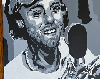 Puede incluir: Una pintura en blanco y negro de un hombre con una gorra y auriculares, sonriendo mientras habla en un micrófono.