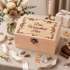 Könnte beinhalten: Eine hellfarbene Holzkiste mit einem dekorativen floralen Design und dem Text "Dein Wunschtext Hier". Die Kiste hat einen Metallverschluss und ist von Blumen, Kerzen und dekorativen Gegenständen umgeben.