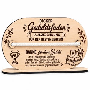 Può includere: Una targa in legno chiaro di forma ovale con una corda bianca orizzontale al centro. Il testo recita: "DICKER Geduldsfaden -AUSZEICHNUNG- FÜR DEN BESTEN LEHRER! DANKE für deine Geduld dein Engagement und dein großes Herz. Danke, dass du uns jeden Tag ein Stück weitergebracht und immer an uns geglaubt hast!"