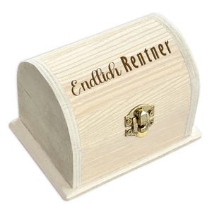 Könnte beinhalten: Eine kleine Holzkiste mit einem Scharnierdeckel und einem goldenen Verschluss. Die Kiste ist weiß lackiert und hat die Worte "Endlich Rentner" auf der Oberseite eingraviert.