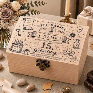 Könnte beinhalten: Eine hellfarbene Holz-Andenkenbox mit Scharnierdeckel und Metallverschluss. Der Deckel ist mit eingravierten Illustrationen verziert, darunter ein Kuchen, Luftballons und der Text "ZEITKAPSEL" und "15. Geburtstag."