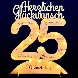 May include: Wooden birthday decoration in the shape of the number 25, with the words "Herzlichen Glückwunsch" at the top and "Zum Geburtstag" at the bottom. The number is illuminated with small lights and includes words like "Optimism" and "Happiness".