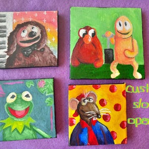 May include: Four small square paintings featuring cartoon characters. One painting shows a brown dog-like character, another shows a red creature and an orange figure, a third shows a green frog, and the last shows a rat. The text "custom slots open!!!" is also visible.