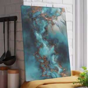 Op de afbeelding: Rechthoekige snijplank met een abstract ontwerp in tinten van turquoise, blauw en koper. Het kunstwerk lijkt op een marmer- of agaatpatroon en voegt een decoratief element toe aan keukengerei. De plank leunt tegen een witte bakstenen muur.