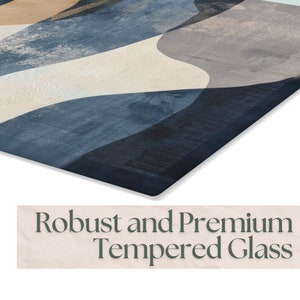 May include: A close-up of a blue, white, and brown abstract design printed on a tempered glass cutting board. The board has a dark blue border.