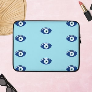 Könnte beinhalten: Eine blaue Laptoptasche mit einem sich wiederholenden Muster aus blauen bösen Augen auf hellblauem Hintergrund.