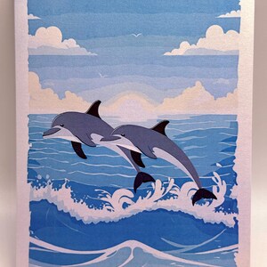 Puede incluir: Ilustración azul y blanca de dos delfines saltando de las olas del océano bajo un cielo nublado. La obra presenta tonos de azul y blanco, con una escena oceánica serena y un cielo azul claro.