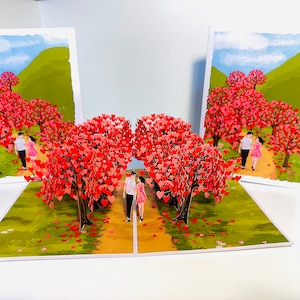 Tarjeta de felicitación 3D emergente con un bosque de cerezos en flor y una pareja enamorada. ¡Feliz aniversario! COMPRA en línea: https://origamipopcards.com/