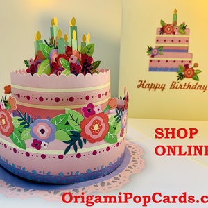 Lindo bolo de feliz aniversário com flores rosas e roxas, cartão pop-up 3D feito à mão com amor. Compre https://origamipopcards.com/