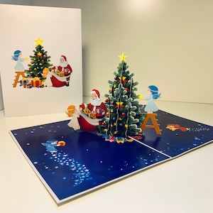 Weihnachtsmann & Baby Engel schmücken Weihnachtsbaum 3D Pop Up Frohe Weihnachten Grußkarte Handmade Shop Online https://origamipopcards.com/