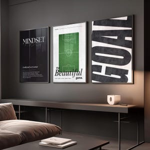 Peut inclure: Trois affiches encadrées sur les thèmes de la motivation et du sport. L'une présente le mot "MINDSET" avec une définition. Une autre affiche un terrain de football avec le texte "the Beautiful game". La troisième affiche le mot "GOAL".