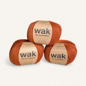 May include: Three balls of orange-brown Petite Wool yarn. Each ball has a brown label with the text "wak we are knitters". The labels also include the text "The Petite Wool" and measurements of 3.5 oz / 100 g - 153 yds / 140 m.