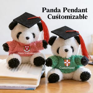 May include: Two panda bear pendants, one in pink and one in green, each wearing a graduation cap and sweater. The pink panda has the text "Happy Graduation!" and the green panda has the text "Customized". The image also has the text "Panda Pendant Customizable".