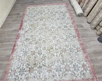 May include: A vintage floral patterned rug with a pink border. The rug has a cream background with a floral pattern in shades of pink, blue, and green.