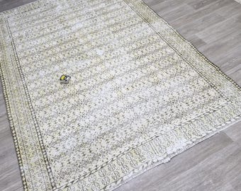 以下が含まれることがあります： 詳細な花柄と装飾的なボーダーが付いた、長方形のオフホワイトのラグ。 ラグは、色あせた色と使い古された質感で、使い古されたヴィンテージの外観をしています。 ラグは、明るい灰色の木製の床に置かれています。